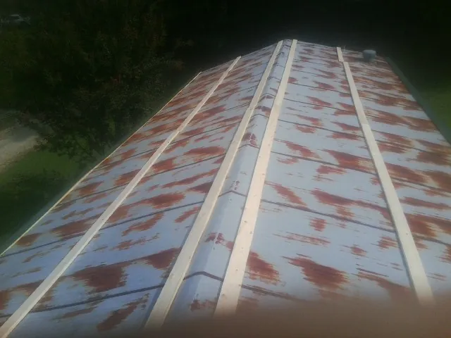 Rusted metal roof panels with new wood purlins before replacement — Storm Damage Roof Repair in Swan Lake by Roofing Brothers