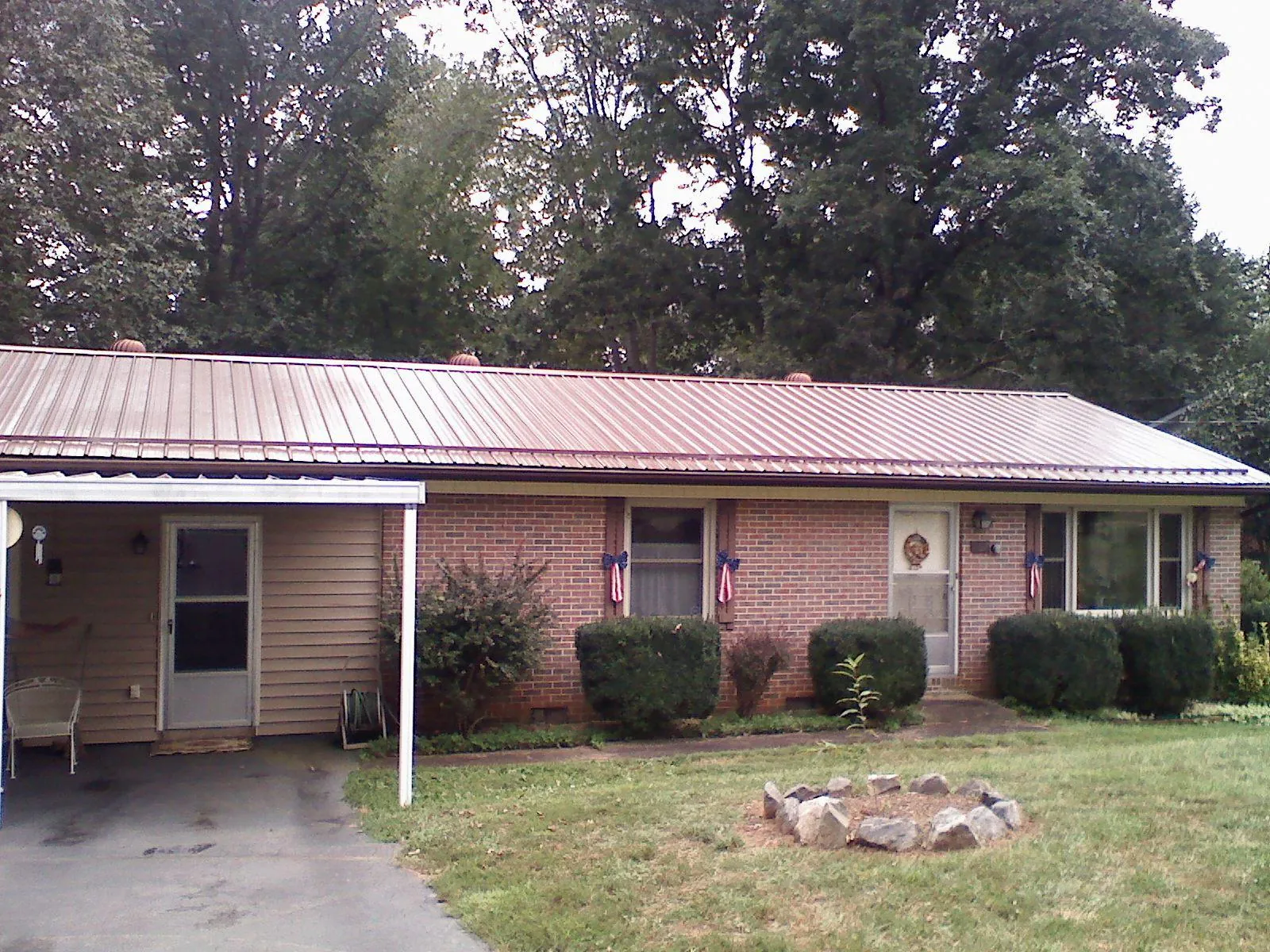 Bronze metal roof and carport on a brick ranch home — Roof Repair work by our crew in Swan Lake